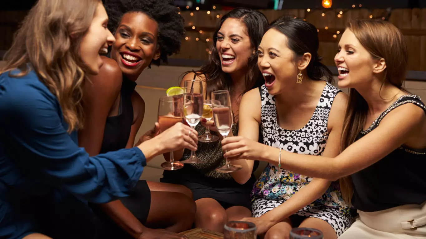 Group Of Female Friends Enjoying Night Out At Rooftop Bar