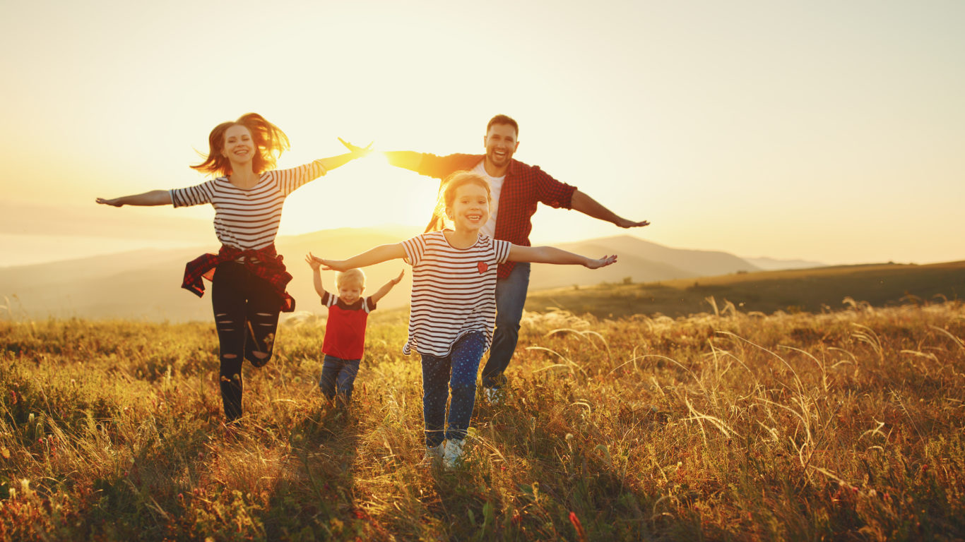 Happy family: mother, father, children son and daughter on sunset