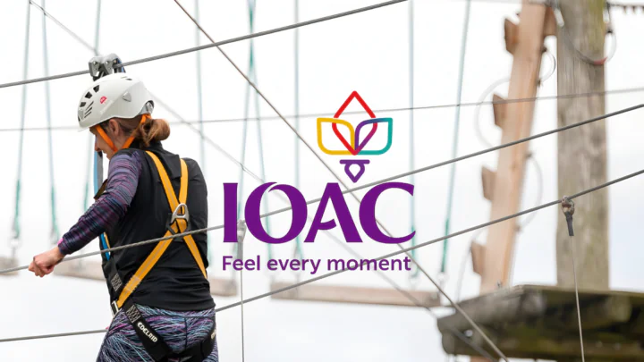 Guest enjoying a thrilling high ropes course experience at IOAC, showcasing adventure and outdoor fun with safety gear in use.
