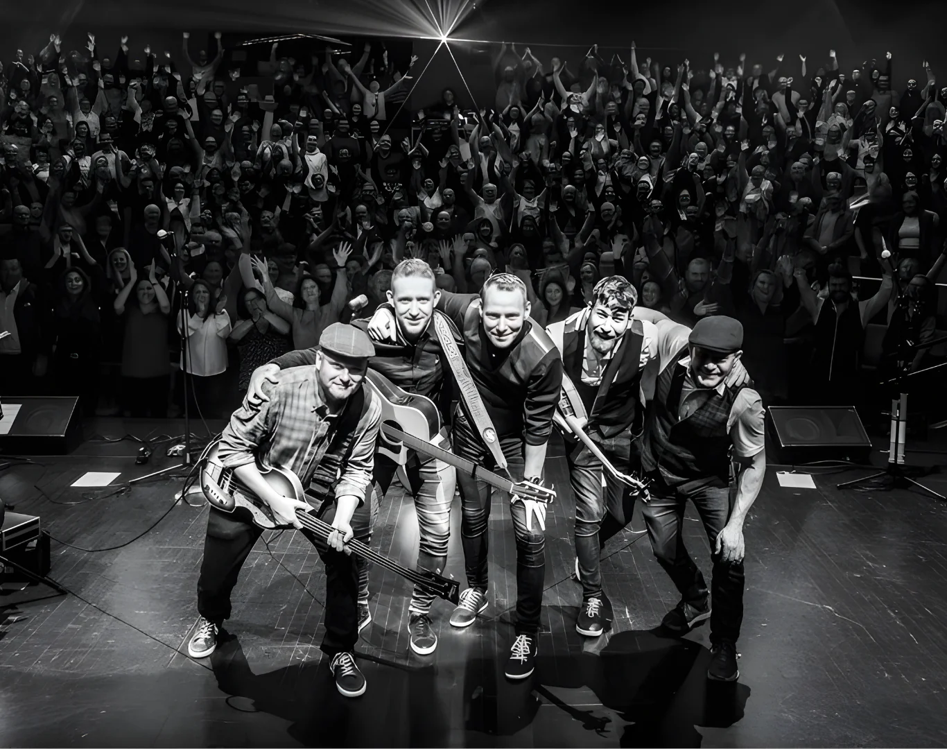 Live band performing to an excited audience in hotel concert hall, creating an unforgettable music experience.