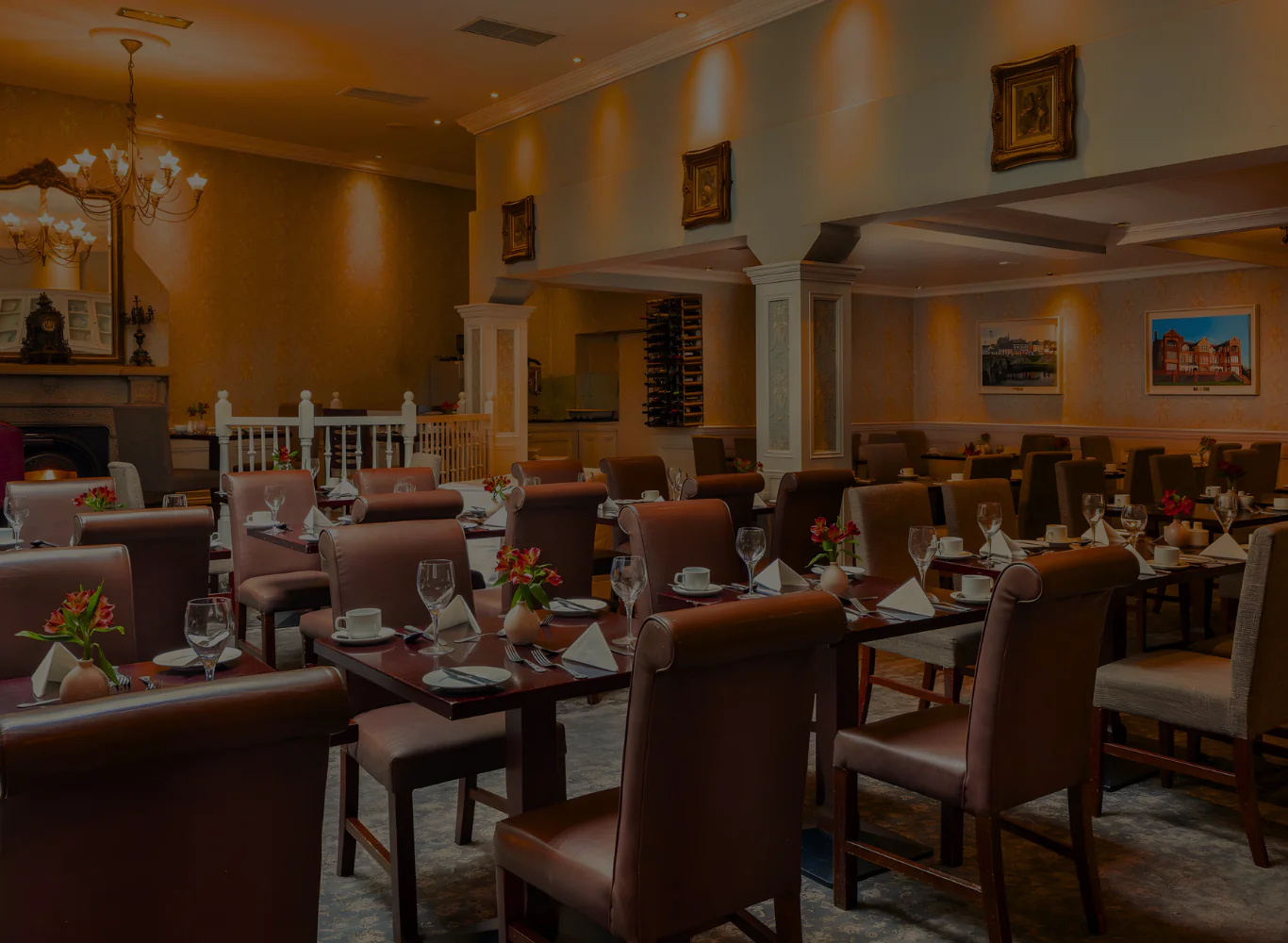 Elegant hotel dining room with chandeliers, cosy seating, fine dinnerware, inviting atmosphere for a luxurious dining experience.