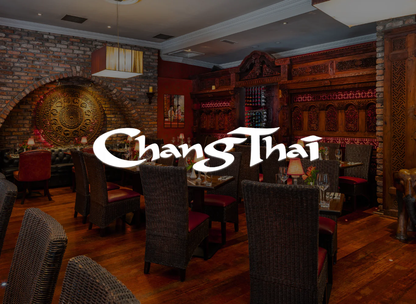 Elegant Thai restaurant with intricate wood decor, warm lighting, and cosy seating for a delightful dining experience.